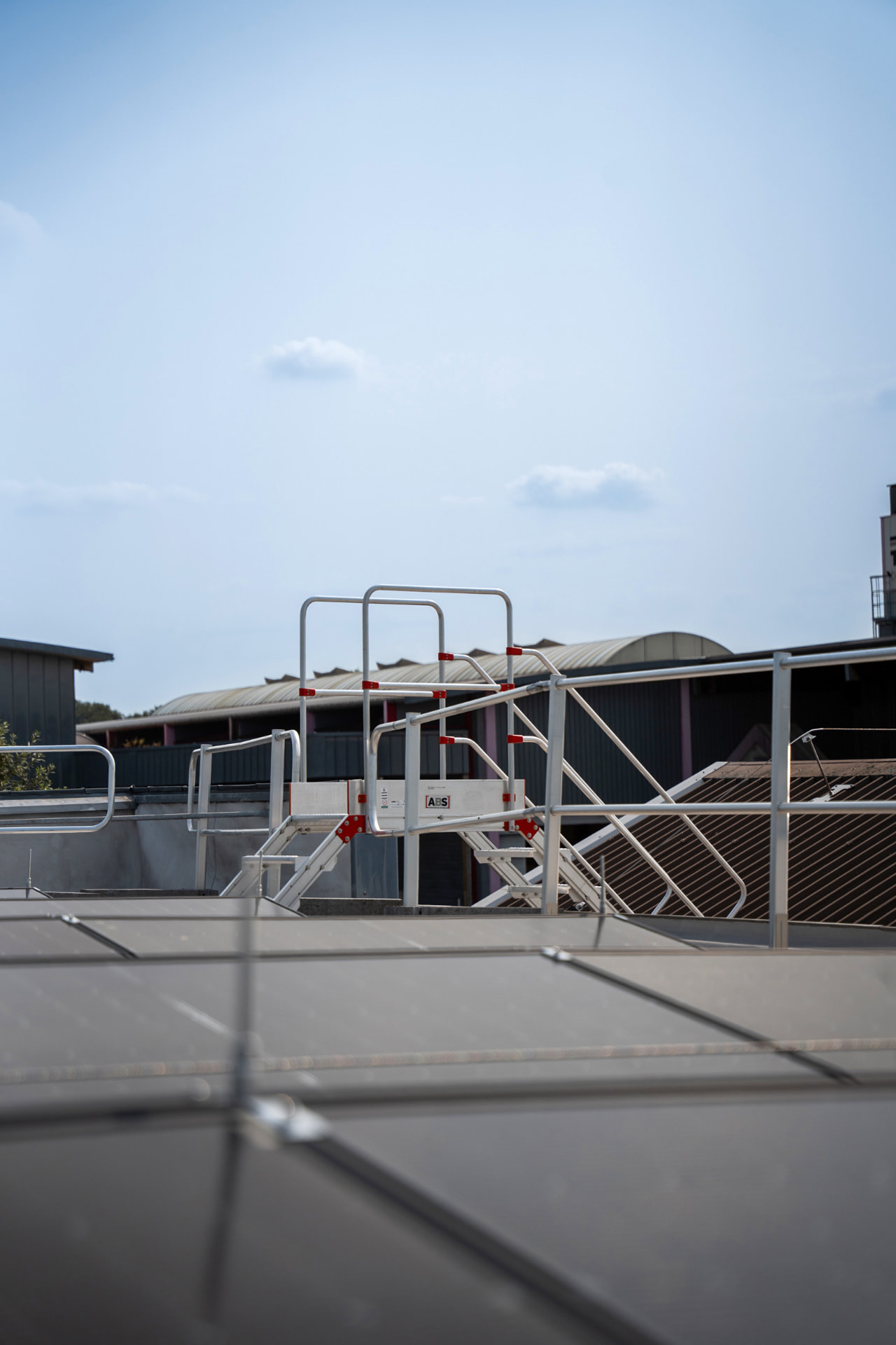 Veilige daktoegang met hekwerk en ladder op een industrieel dak